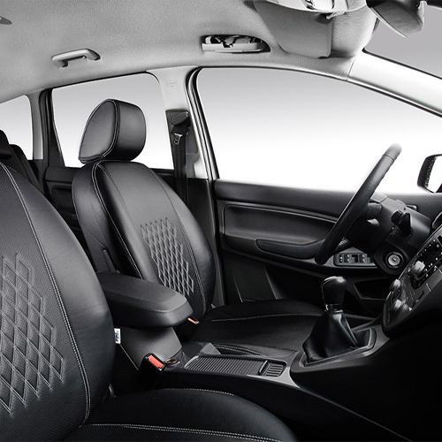 Interiörbild av en bil med svarta quiltade säten från PeBe, skräddarsydda för perfekt passform och kvalitet.