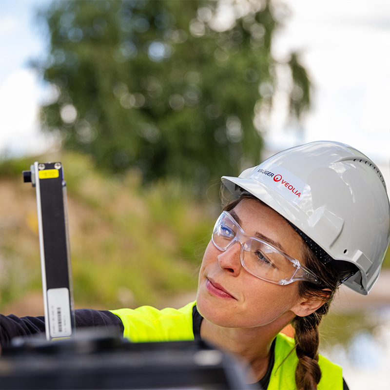 Medarbetare från Krüger Veolia i arbetskläder och hjälm, fotograferad ute på en arbetsplats för verksamhetsfotografering